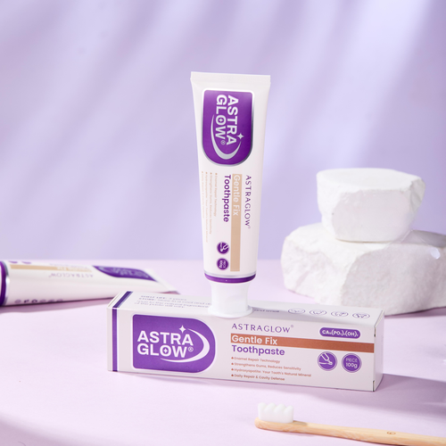 AstraGlow Gentle Fix Toothpaste tube and box on lavender surface with a bamboo toothbrush